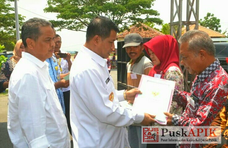 Bupati Junaedi menyerahkan sertifikat tanah ke warga (foto : red)